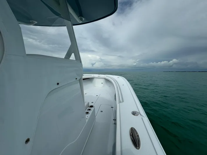  Yacht Photos Pics 2025 Yellowfin 32 boat on calm sea under cloudy sky.