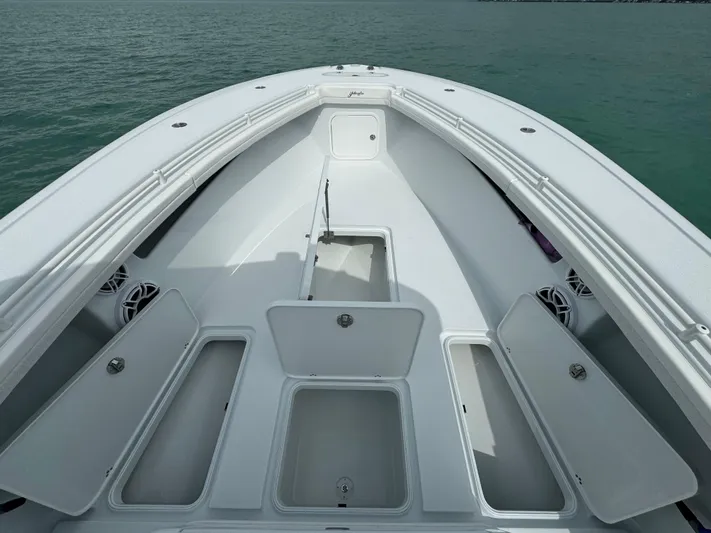  Yacht Photos Pics 2025 Yellowfin 32 boat with open storage compartments on calm water.