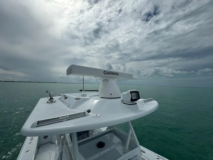  Yacht Photos Pics 2025 Yellowfin 32 boat with Garmin radar on open sea under cloudy sky.