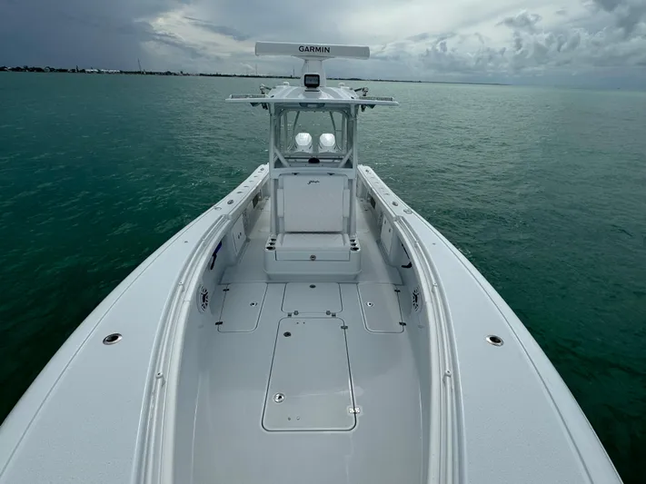  Yacht Photos Pics 2025 Yellowfin 32 boat on calm sea under cloudy sky.