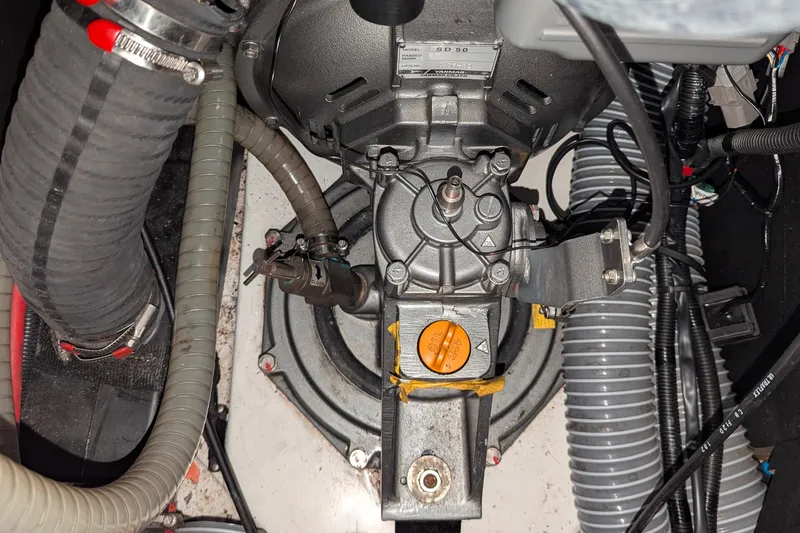 Windwaker Yacht Photos Pics Engine compartment of a 2013 Jeanneau 41 Deck Salon sailboat, showing mechanical components and hoses.