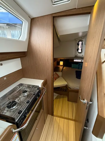 Windwaker Yacht Photos Pics Interior of 2013 Jeanneau 41 DS yacht, featuring a compact kitchen and cozy bedroom.