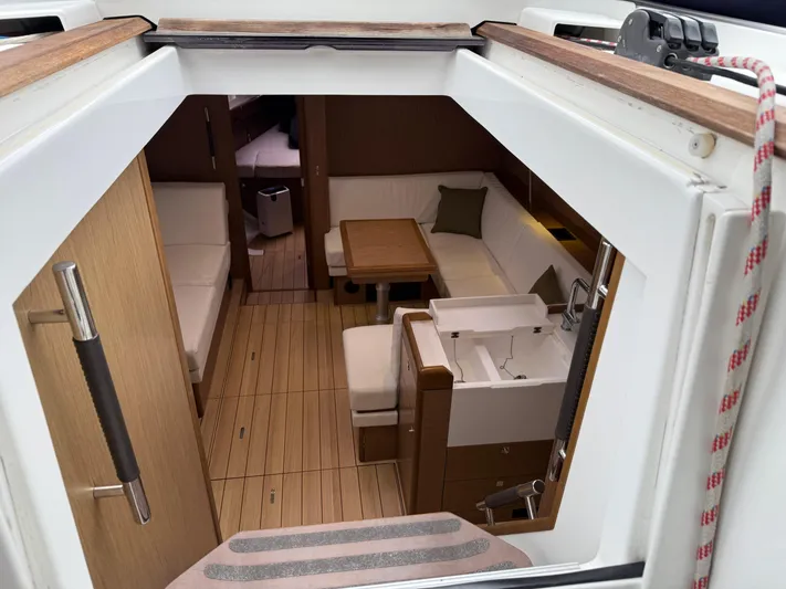 Windwaker Yacht Photos Pics Interior view of 2013 Jeanneau 41 DS sailboat, featuring elegant wood flooring and cozy seating.