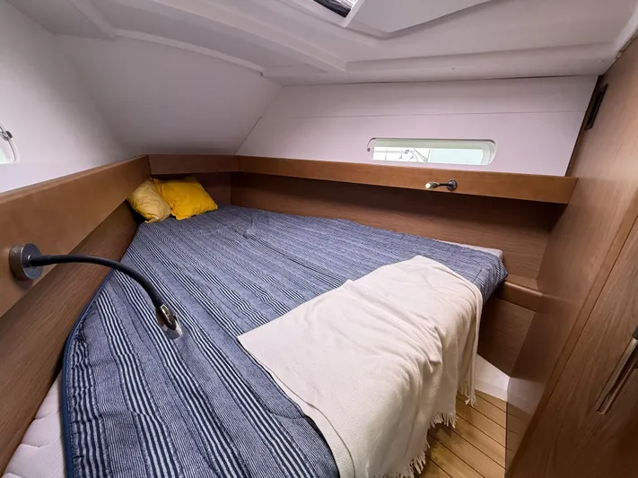 Windwaker Yacht Photos Pics Cozy cabin interior of 2013 Jeanneau 41 DS sailboat with bed and wooden accents.