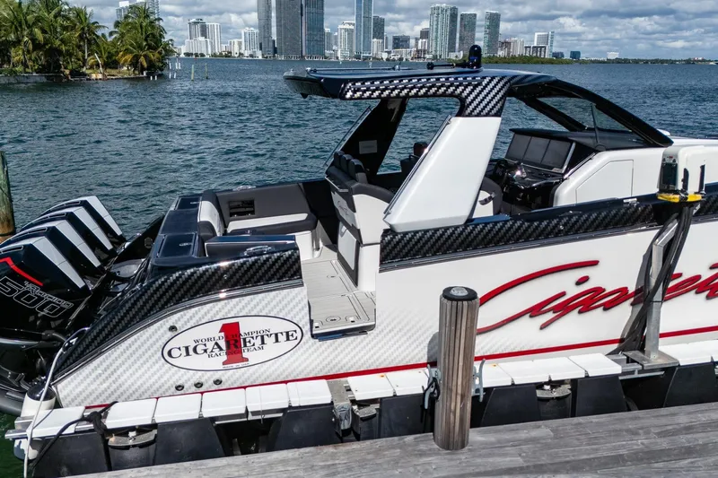  Yacht Photos Pics 2024 Cigarette 42 Auroris boat docked with city skyline in background.