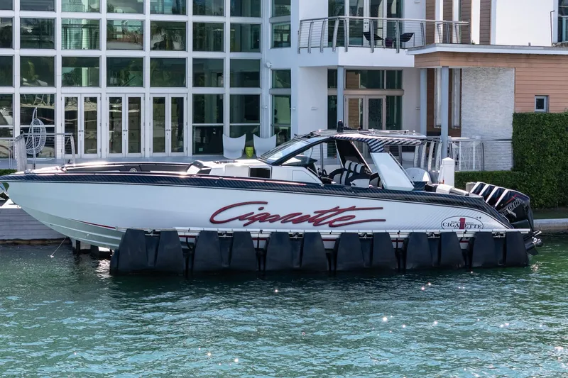  Yacht Photos Pics 2024 Cigarette 42 Auroris boat docked by modern waterfront home.