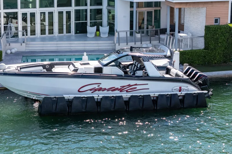  Yacht Photos Pics 2024 Cigarette 42 Auroris luxury boat docked by modern waterfront home.