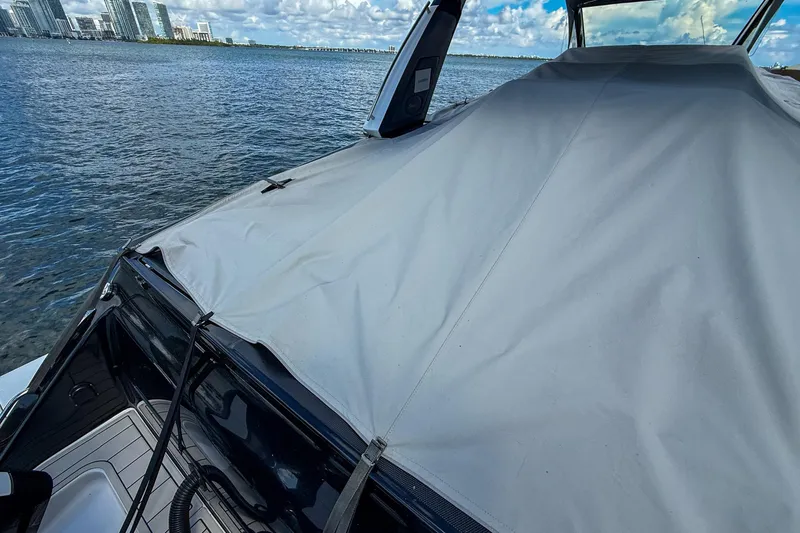  Yacht Photos Pics 2024 Cigarette 42 Auroris boat covered, docked by waterfront with city skyline.