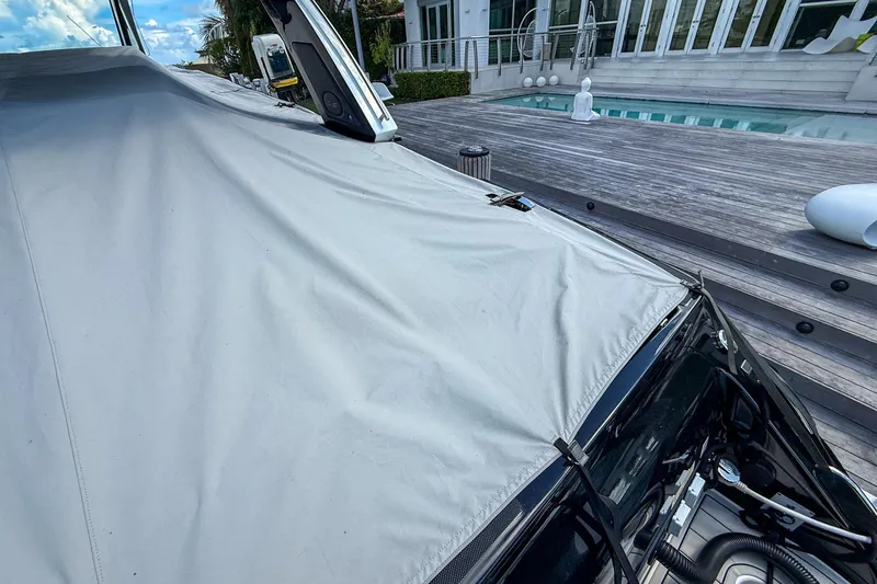  Yacht Photos Pics 2024 Cigarette 42 Auroris boat covered, docked near modern poolside deck.