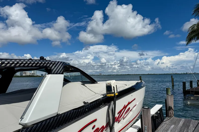  Yacht Photos Pics 2024 Cigarette 42 Auroris boat docked by the water under a vibrant blue sky.