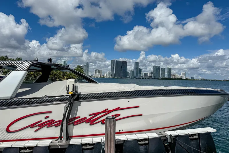  Yacht Photos Pics 2024 Cigarette 42 Auroris boat docked with city skyline in background.