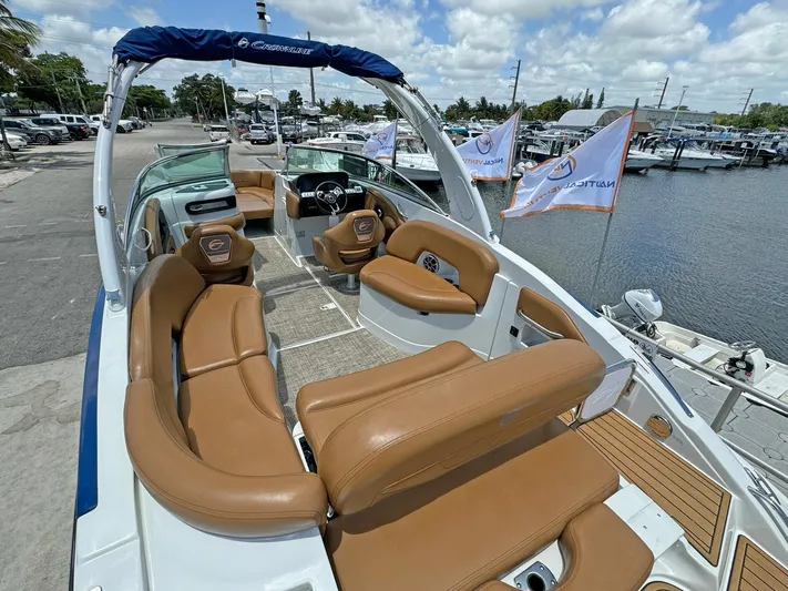  Yacht Photos Pics 2024 Crownline 290 XSS boat with tan seating, docked by a marina.