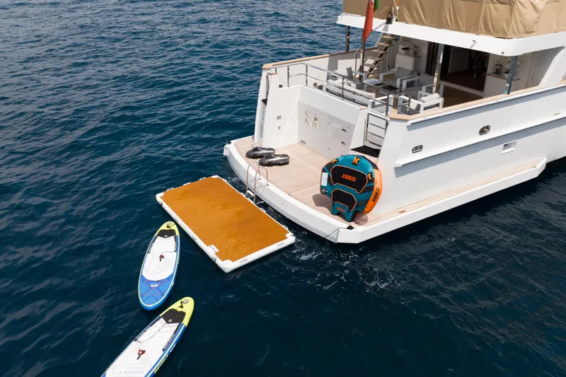 Eva Yacht Photos Pics Luxury 1993 Cheoy Lee Custom yacht with paddleboards and inflatable dock on the ocean.