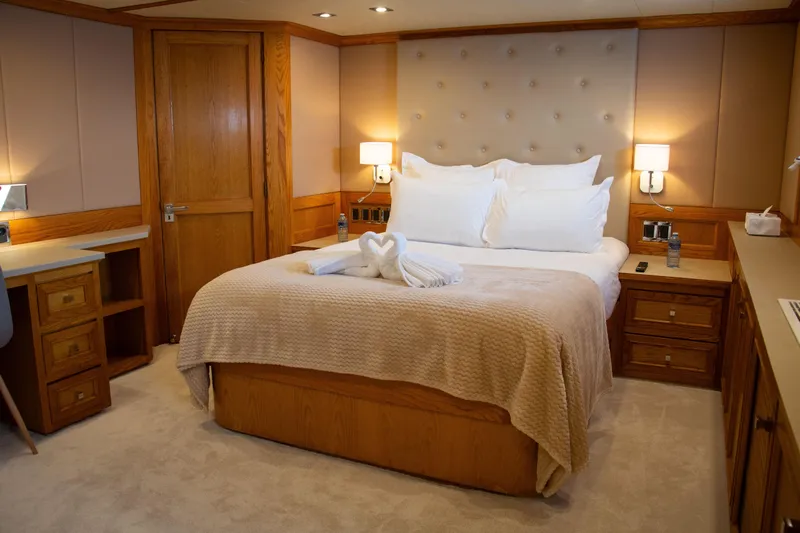 Eva Yacht Photos Pics Luxurious bedroom interior on 1993 Cheoy Lee Custom yacht, featuring elegant wood accents.