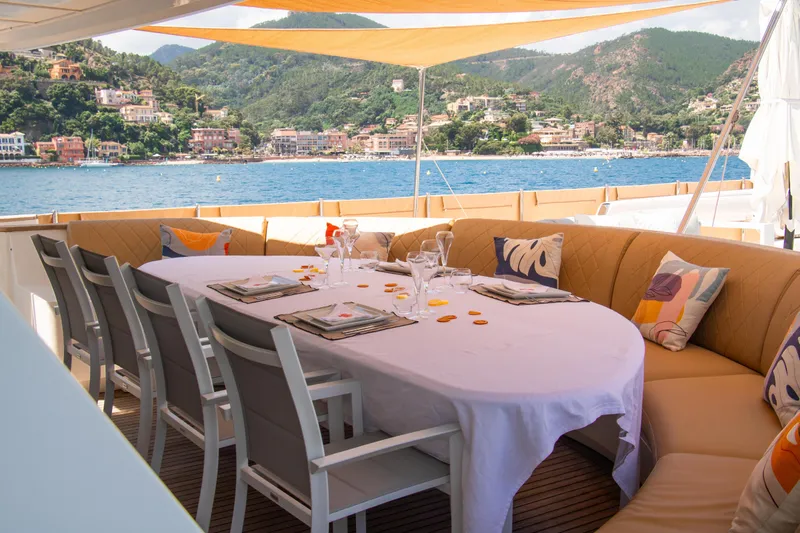 Eva Yacht Photos Pics Luxurious dining area on 1993 Cheoy Lee Custom yacht with scenic coastal view.