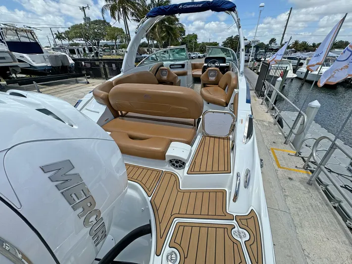  Yacht Photos Pics 2024 Crownline 290 XSS boat with tan seating and Mercury engine at a marina.