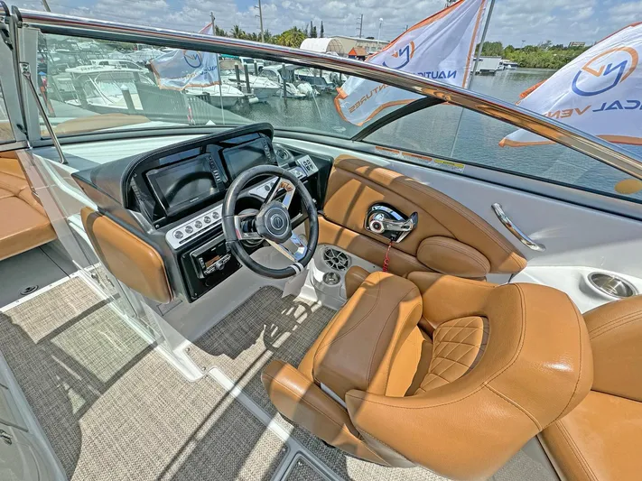  Yacht Photos Pics 2024 Crownline 290 XSS boat interior with tan leather seats and modern dashboard.