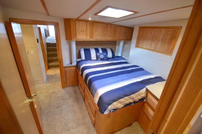 Hopium Yacht Photos Pics Cozy bedroom in 2004 Chesapeake 58 boat with striped bedding and wooden cabinetry.
