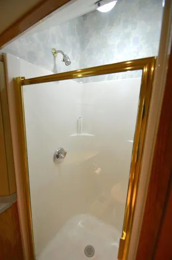 Hopium Yacht Photos Pics Shower area in 2004 Chesapeake 58 boat with gold trim and white walls.