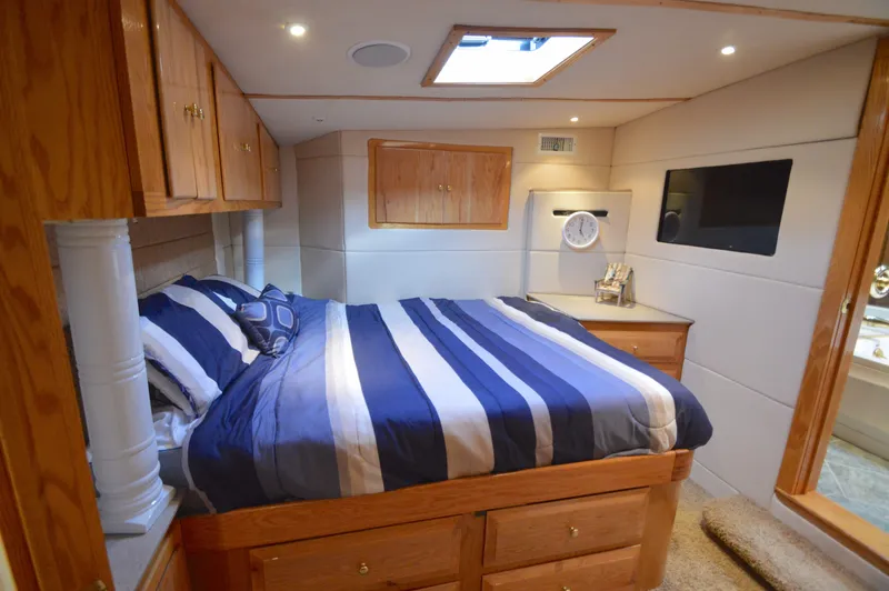 Hopium Yacht Photos Pics Luxurious cabin interior of 2004 Chesapeake 58 boat with striped bedding and wooden accents.