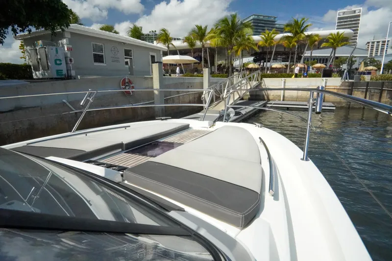  Yacht Photos Pics 2021 Jeanneau Leader 10.5 WA boat docked near palm trees and modern buildings.