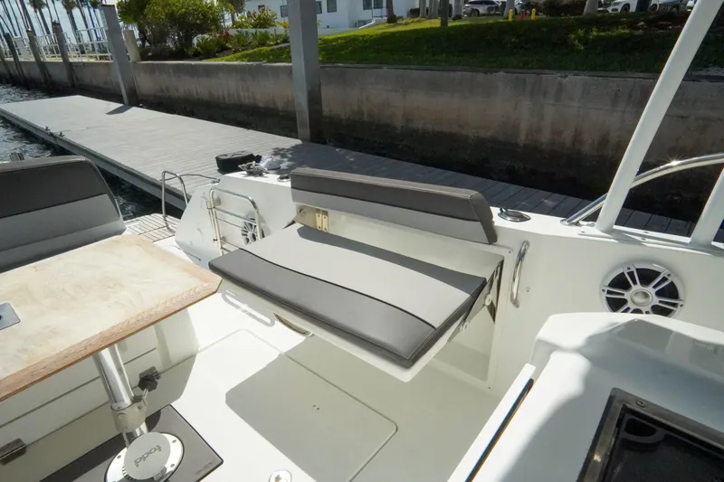  Yacht Photos Pics 2021 Jeanneau Leader 10.5 WA boat interior with seating and table near dock.