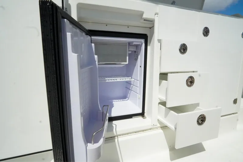  Yacht Photos Pics 2021 Jeanneau Leader 10.5 WA boat interior with open fridge and storage drawers.