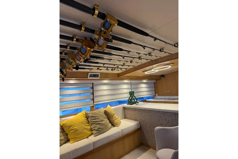  Yacht Photos Pics Luxurious 1989 Buddy Davis 61 yacht interior with fishing rods and cozy seating area.