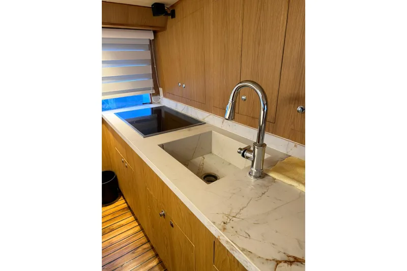  Yacht Photos Pics Luxurious kitchen interior of 1989 Buddy Davis 61 yacht with marble countertop and modern fixtures.