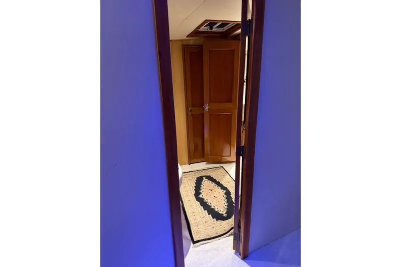  Yacht Photos Pics Interior view of 1989 Buddy Davis 61 yacht, featuring wooden doors and a decorative rug.