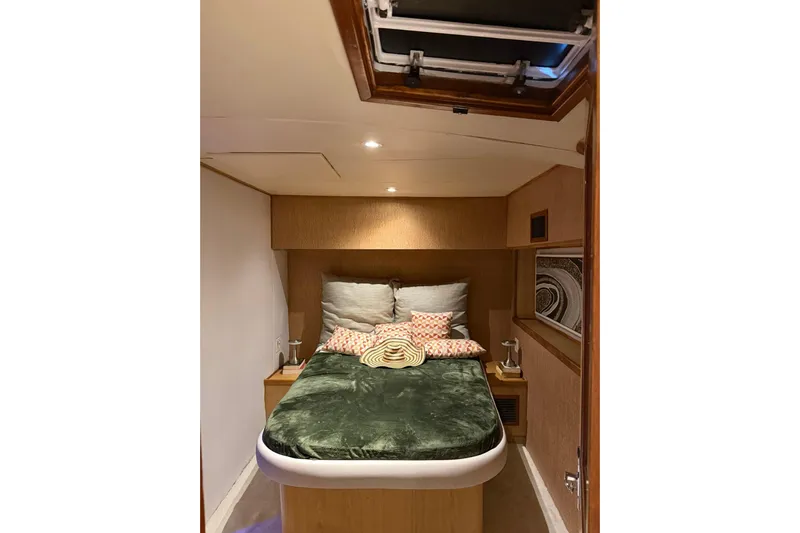  Yacht Photos Pics Cozy bedroom interior of 1989 Buddy Davis 61 yacht with plush bedding and warm lighting.