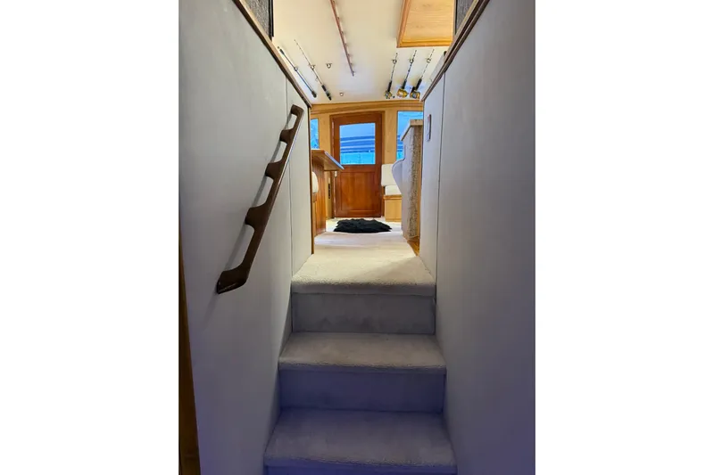  Yacht Photos Pics Interior view of 1989 Buddy Davis 61 yacht, featuring carpeted stairs and wooden accents.