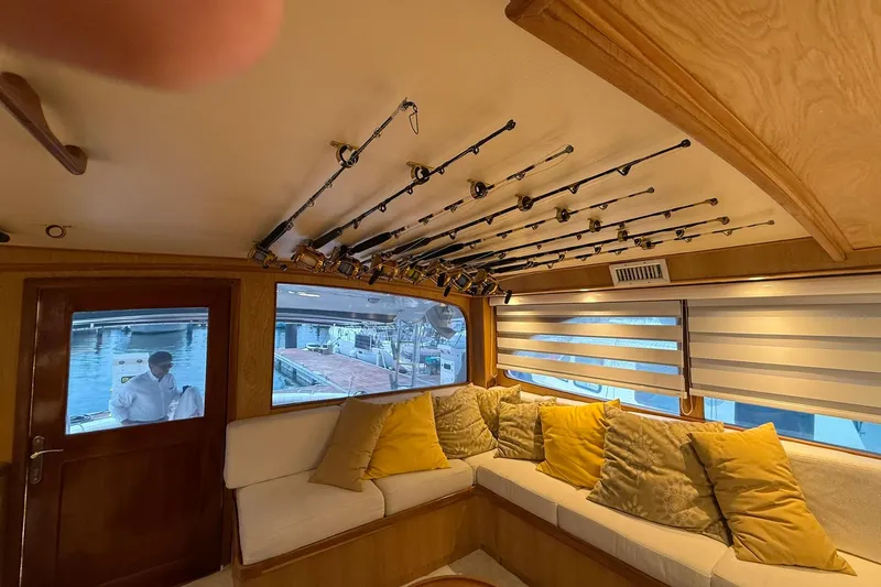  Yacht Photos Pics Interior of 1989 Buddy Davis 61 yacht with fishing rods and cozy seating area.