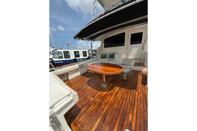  Yacht Photos Pics 1989 Buddy Davis 61 yacht with wooden deck and seating area, docked at marina.