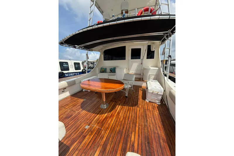  Yacht Photos Pics 1989 Buddy Davis 61 yacht deck with wooden flooring, table, and seating area.