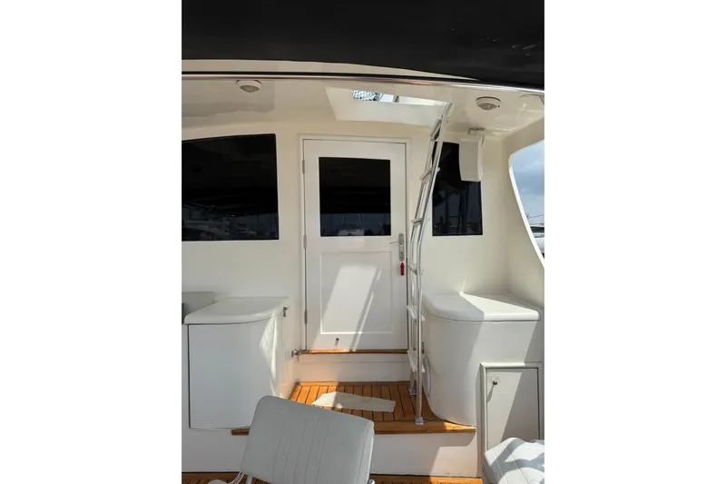  Yacht Photos Pics 1989 Buddy Davis 61 yacht interior with white door and seating, featuring wooden flooring.