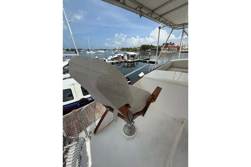  Yacht Photos Pics Captain's chair on 1989 Buddy Davis 61 yacht, overlooking marina with boats and clear sky.