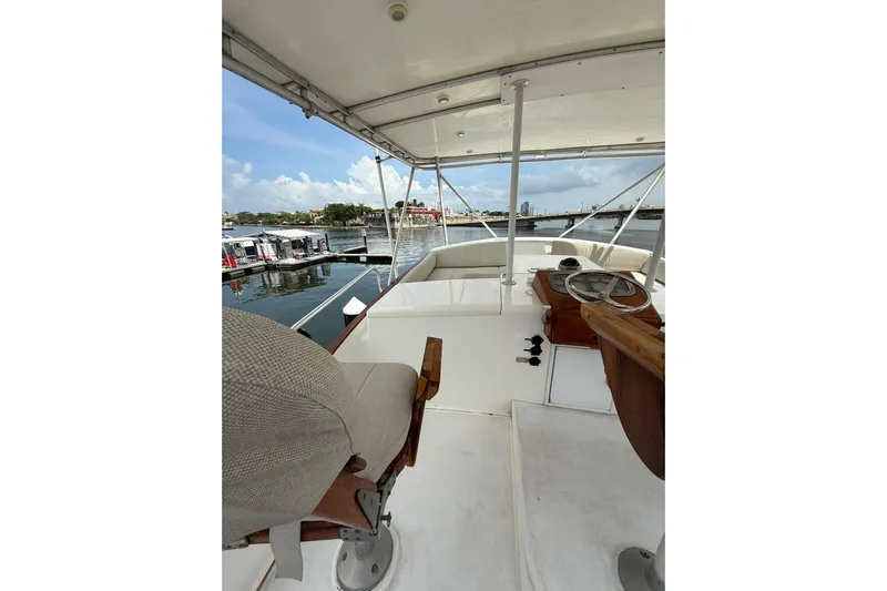  Yacht Photos Pics 1989 Buddy Davis 61 yacht helm with marina view, featuring steering wheel and seating.