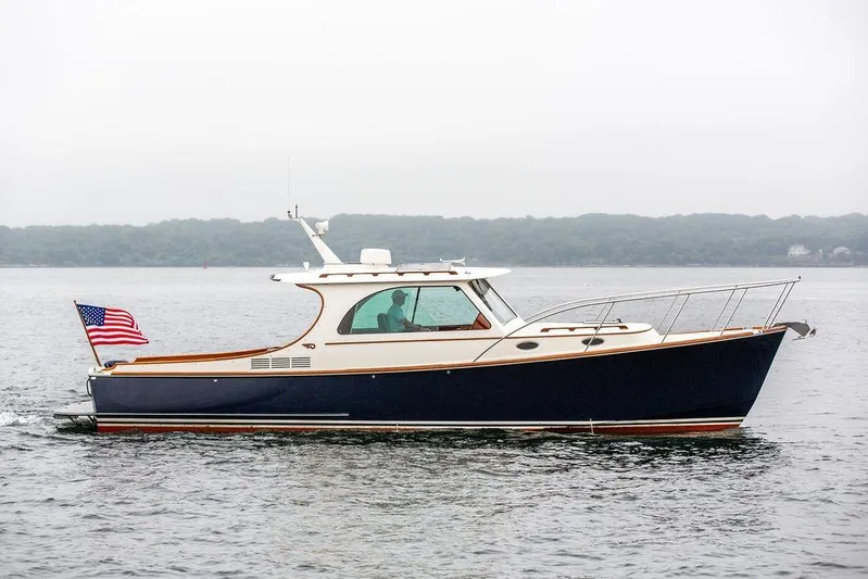 Friendship Yacht Photos Pics 2010 Hinckley Picnic Boat MKIII cruising on calm waters with American flag.