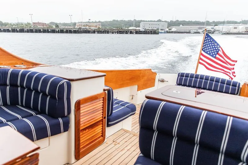 Friendship Yacht Photos Pics Hinckley Picnic Boat MKIII 2010 with striped seating and American flag on open water.