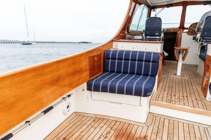 Friendship Yacht Photos Pics Hinckley Picnic Boat MKIII 2010 interior with wooden deck and striped seating.