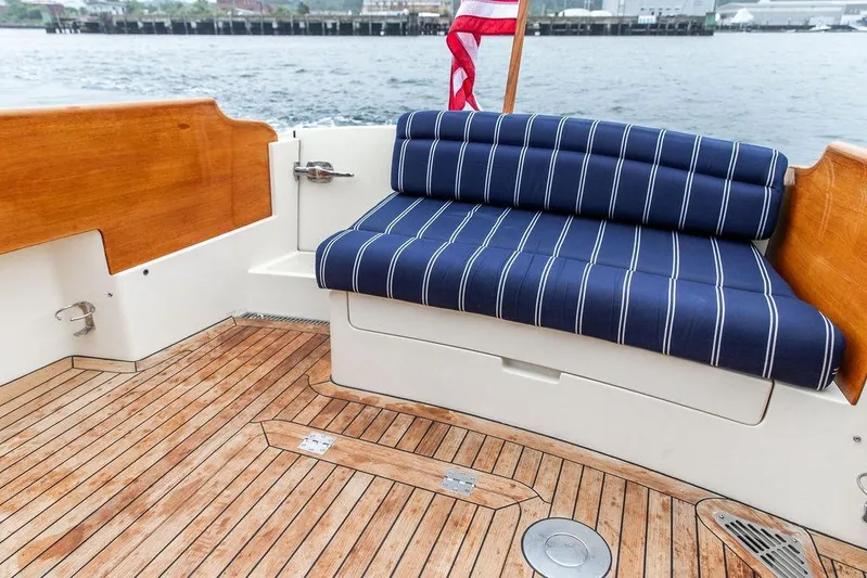 Friendship Yacht Photos Pics Hinckley Picnic Boat MKIII 2010 with striped seating and wooden deck, dockside view.