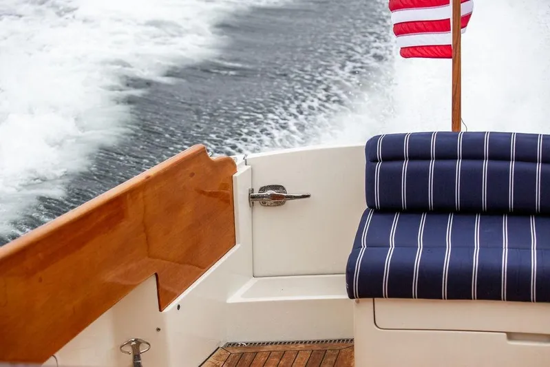 Friendship Yacht Photos Pics Hinckley Picnic Boat MKIII 2010 with striped seating and American flag on water.