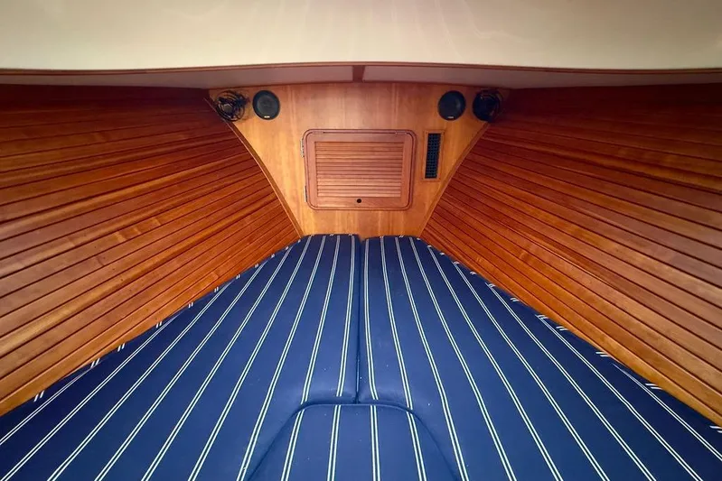 Friendship Yacht Photos Pics Interior of 2010 Hinckley Picnic Boat MKIII with wooden paneling and striped bedding.