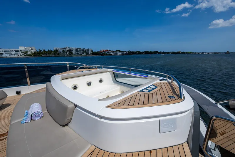 Splash Yacht Photos Pics Luxurious 2022 Princess X95 yacht with jacuzzi on deck, overlooking serene waters.