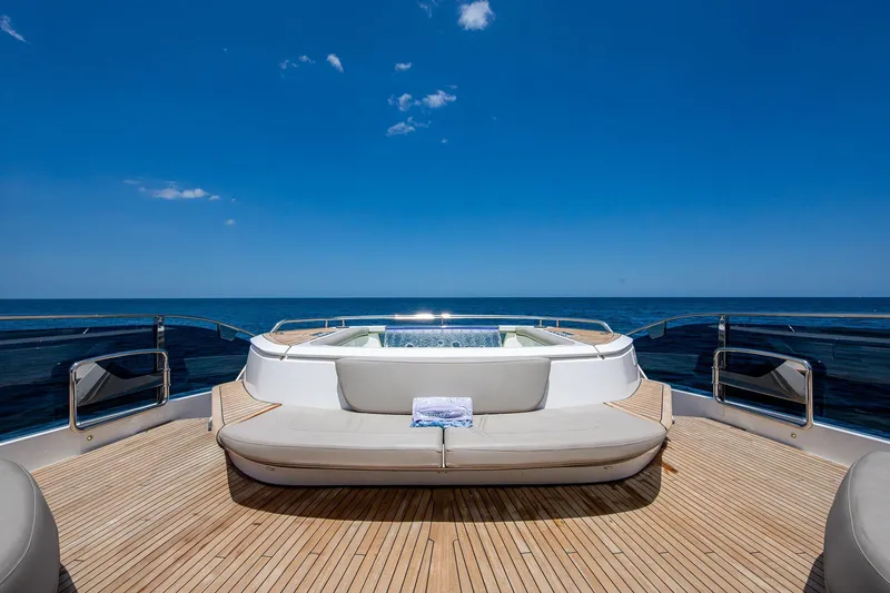 Splash Yacht Photos Pics Luxurious 2022 Princess X95 yacht deck with jacuzzi, ocean view, and clear blue sky.