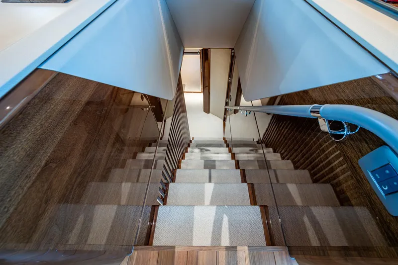 Splash Yacht Photos Pics Luxurious staircase inside 2022 Princess X95 yacht, featuring sleek wood and modern design.