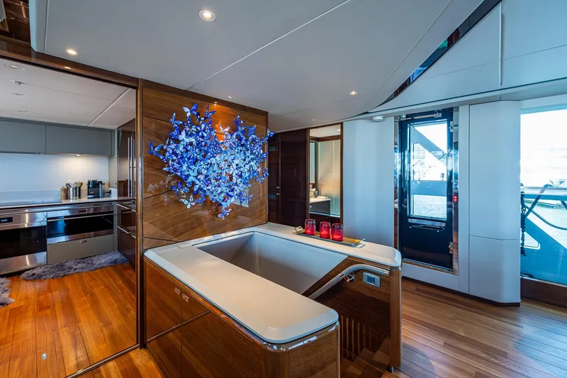 Splash Yacht Photos Pics Luxurious interior of 2022 Princess X95 yacht with modern kitchen and artistic wall decor.