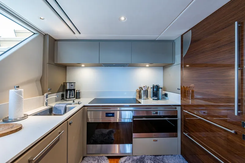 Splash Yacht Photos Pics Modern kitchen interior on 2022 Princess X95 yacht, featuring sleek appliances and wood finishes.