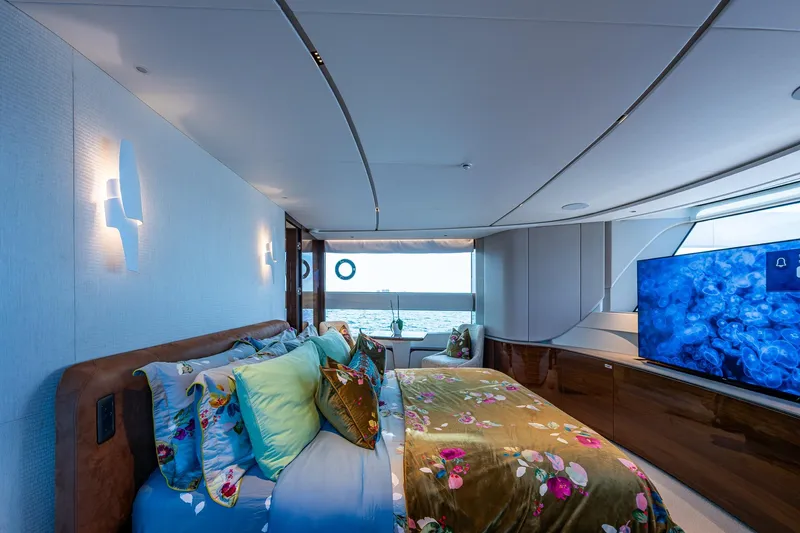 Splash Yacht Photos Pics Luxurious 2022 Princess X95 yacht bedroom with ocean view, floral bedding, and large TV.